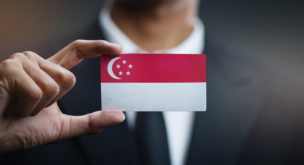 Businessman holding a Singapore flag card